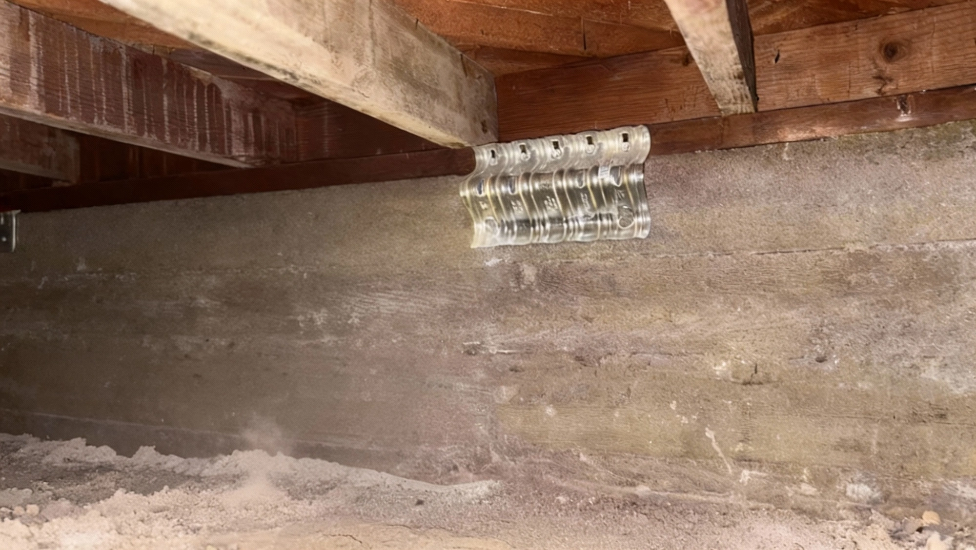 Newly installed seismic retrofit brackets securing wood framing to concrete foundation